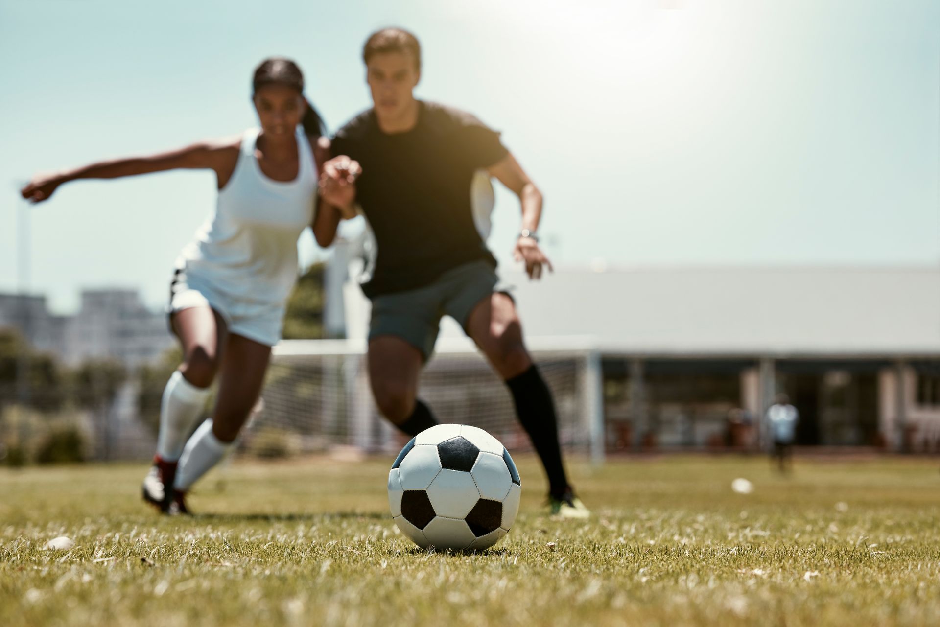 Two soccer athletes competing for the ball